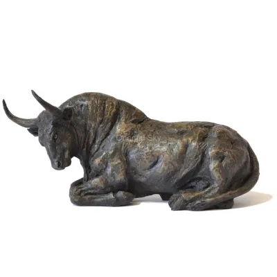 Toro in bronzo a grandezza naturale inginocchiato sulla statua a terra