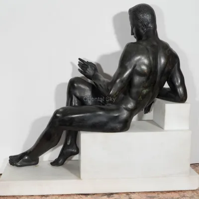 Nackter junger Mann der Bronze, der auf der männlichen Skulptur der Treppenstatue sitzt
