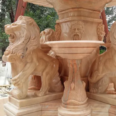 Gran fuente de piedra de mármol rojo al aire libre con estatuas de hombres y leones