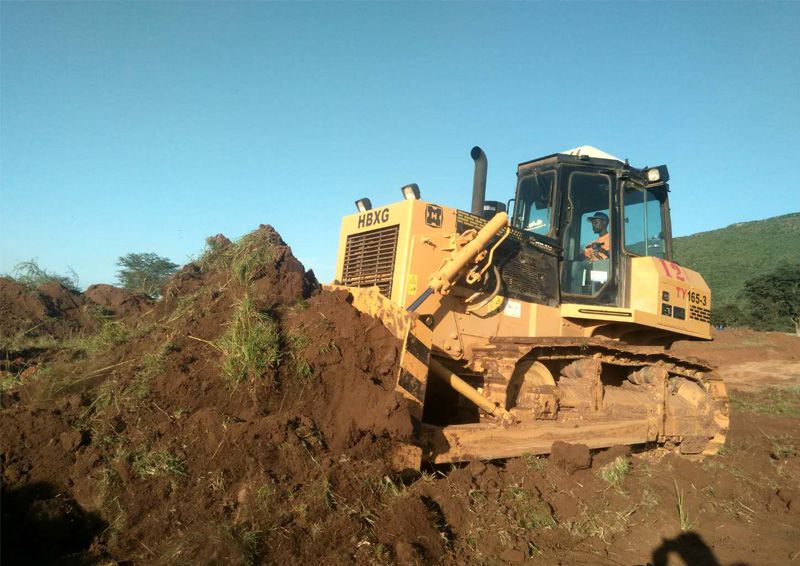 A motor grader, resembling the artist of roads, carefully shapes and levels the ground, ensuring smooth and safe surfaces for travelers to traverse.