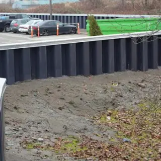 Sheet pile walls are thin retaining walls used to hold back soil, water or any other fill material.