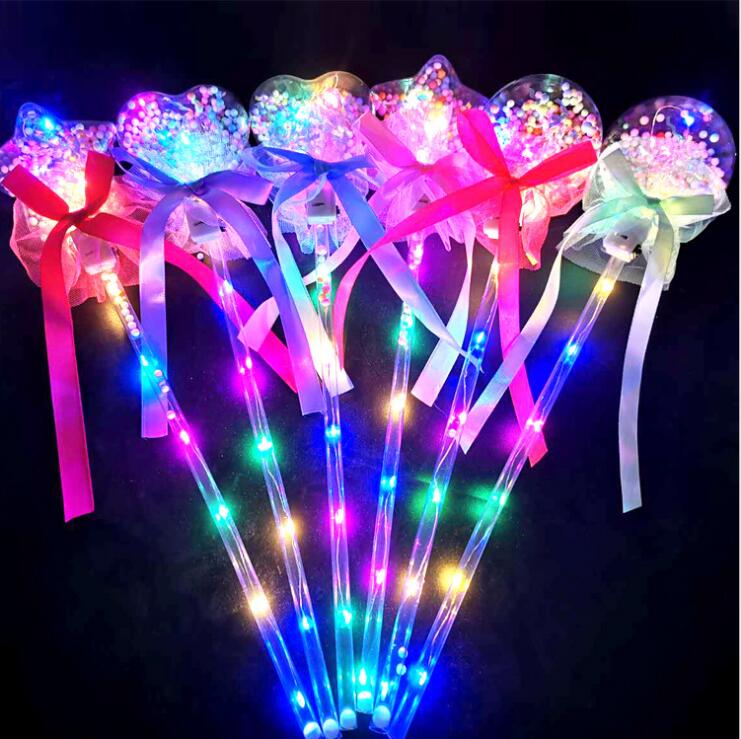 illuminando i bastoncini magici a LED con la bacchetta magica per il viso, i bambini, la principessa glitterata