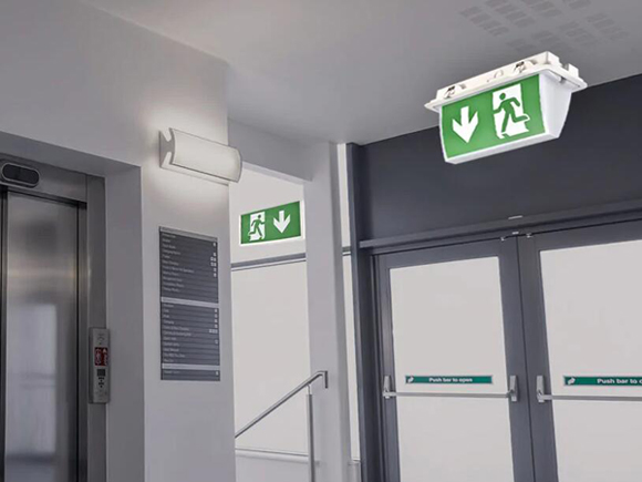 Where should emergency light fittings be located?